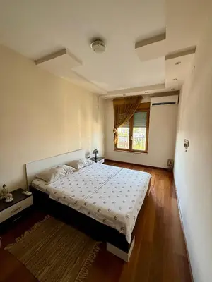 a bedroom with a bed and a window at Urban Suite Athos in Podgorica