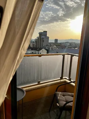a balcony with a chair and a view of the city at Urban Suite Athos in Podgorica