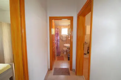 a hallway of a bathroom with a toilet and a sink at Apartments Stevan in Bar