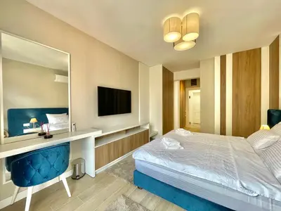 a bedroom with a bed and a desk and a television at Comfort Apartments Pasha in Budva
