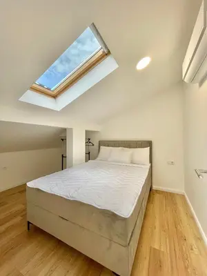 a bedroom with a bed and a skylight at Comfort Apartments Pasha in Budva