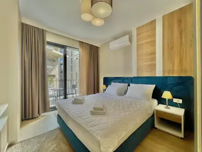 a bedroom with a blue bed and a balcony at Comfort Apartments Pasha in Budva