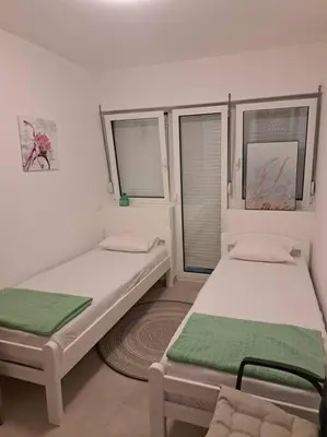two beds in a room with two windows at Mina in Budva