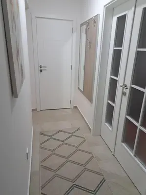 a hallway with a door and a room with a tile floor at Mina in Budva