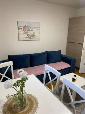 a living room with a table and chairs and a couch at Mina in Budva
