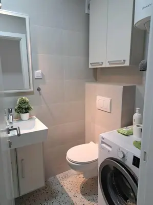 a bathroom with a toilet and a washing machine at Mina in Budva