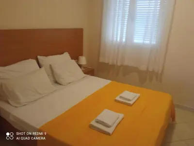 a bedroom with a bed with two towels on it at APARTMANI LUX SEA in Utjeha