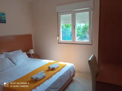 a bedroom with a bed with two towels on it at APARTMANI LUX SEA in Utjeha