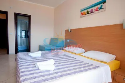 a bedroom with a large bed with a blue chair at APARTMANI LUX SEA in Utjeha