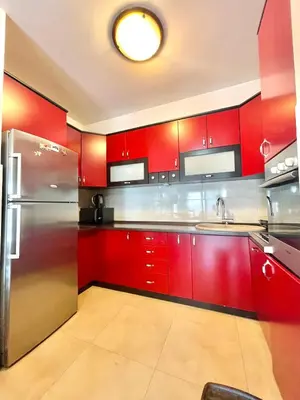 a kitchen with red cabinets and a stainless steel refrigerator at Comfort Apartments Aleksic in Budva