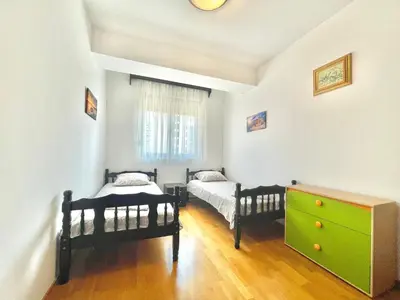 a bedroom with two beds and a dresser and a window at Comfort Apartments Aleksic in Budva