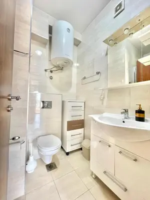 a white bathroom with a toilet and a sink at Comfort Apartments Aleksic in Budva
