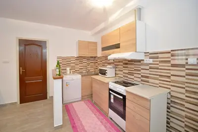 a kitchen with wooden cabinets and a stove top oven at Apartment Gara in Kotor