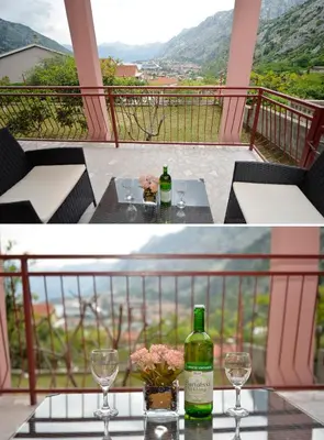 two bottles of wine and glasses on a table on a balcony at Apartment Gara in Kotor