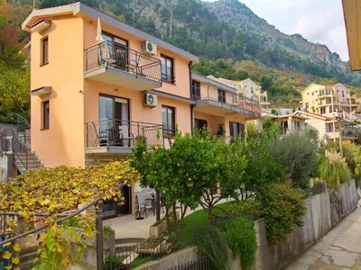 a building with balconies and trees in a town at Apartments Andrija in Kotor