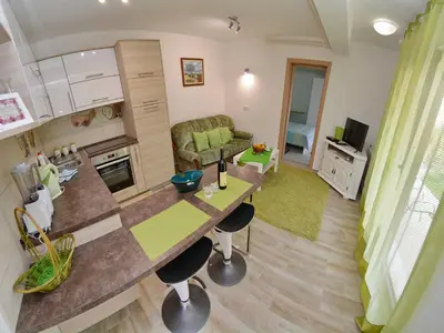 a kitchen and living room with a table and a couch at Apartments Andrija in Kotor