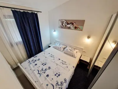 a small room with a bed and a window at Apartments Andrija in Kotor