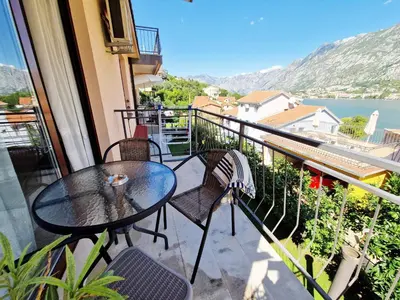 a table and chairs on a balcony with a view at Apartments Andrija in Kotor