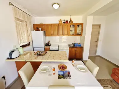 a kitchen with a white table and a white refrigerator at Apartments Andrija in Kotor