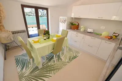 a kitchen with a table and chairs in a kitchen at Apartments Andrija in Kotor