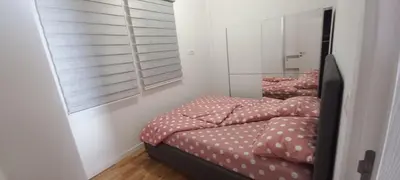 a bedroom with a bed with polka dot sheets and a mirror at RELAX in Podgorica