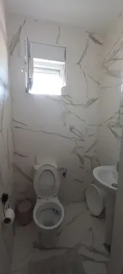 a white bathroom with a toilet and a sink at RELAX in Podgorica