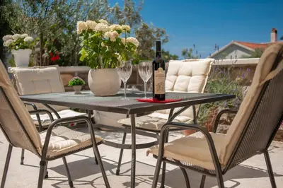 a table with a bottle of wine and two glasses at Villa Stevan in Sveti Stefan