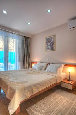 a bedroom with a large bed and a window at Villa Stevan in Sveti Stefan