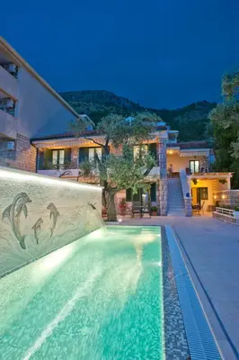 a swimming pool in front of a house at Villa Stevan in Sveti Stefan
