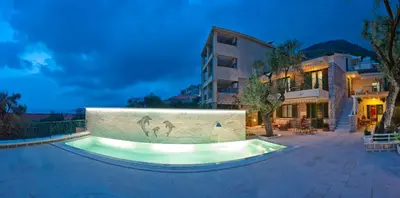 a swimming pool in front of a building at Villa Stevan in Sveti Stefan