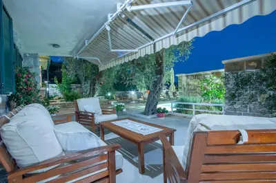a patio with two chairs and a table and a couch at Villa Stevan in Sveti Stefan