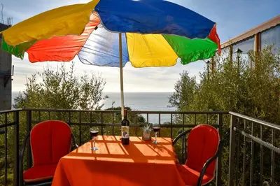 a table with a colorful umbrella on a balcony at Apartments Susanna in Ulcinj