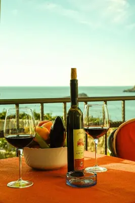 a bottle of wine and two glasses on a table at Apartments Susanna in Ulcinj