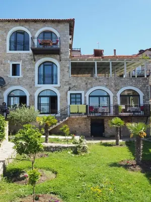 an old stone building with palm trees in front of it at Apartments Susanna in Ulcinj