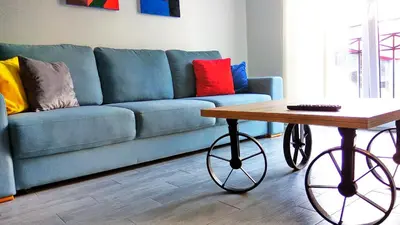 a blue couch with colorful pillows and a coffee table at Apartments Grgurević in Kotor