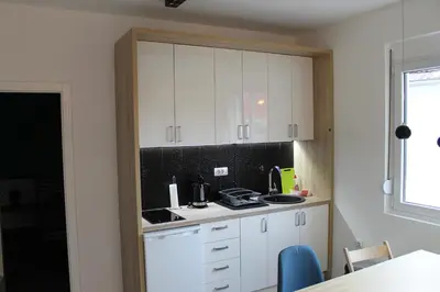 a kitchen with white cabinets and a counter top at Apartments Grgurević in Kotor