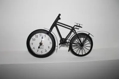a bike hanging on a wall with a clock at Apartments Grgurević in Kotor