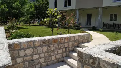 a stone retaining wall in front of a house at Apartments Grgurević in Kotor