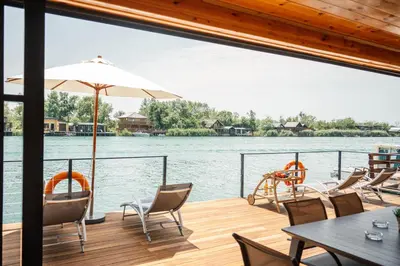 a deck on a boat with chairs and an umbrella at Congo Bungalow in Ulcinj