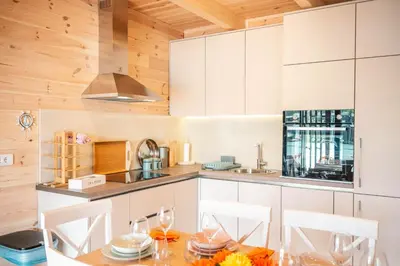 a kitchen with white cabinets and a wooden ceiling at Congo Bungalow in Ulcinj