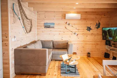 a living room with a couch and wooden walls at Congo Bungalow in Ulcinj
