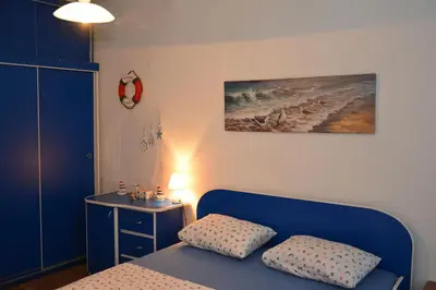 a room with a bed and a table and a painting at Apartment Pela in Kotor