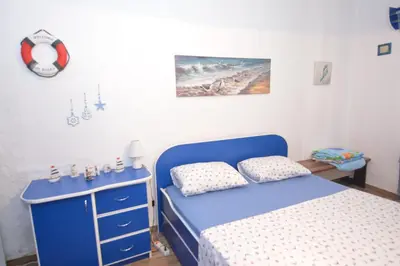 a bedroom with a blue bed and a blue dresser at Apartment Pela in Kotor