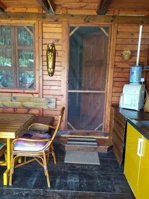 a cabin with a table and a chair in front of a door at Holiday Home Bojanka in Ulcinj