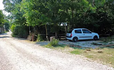 a white car parked on the side of a dirt road at Holiday Home Bojanka in Ulcinj