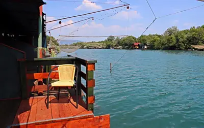 a chair sitting on the end of a boat on the water at Holiday Home Bojanka in Ulcinj