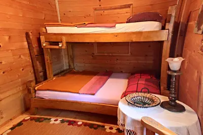 two bunk beds in a wooden room with a table at Holiday Home Bojanka in Ulcinj