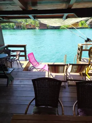 a group of chairs and tables on a deck next to the water at Holiday Home Bojanka in Ulcinj