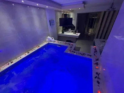 a large swimming pool in a bathroom with a tub at Apartments Pericic in Sutomore