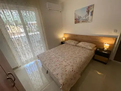a small bedroom with a bed and a window at Apartments Pericic in Sutomore